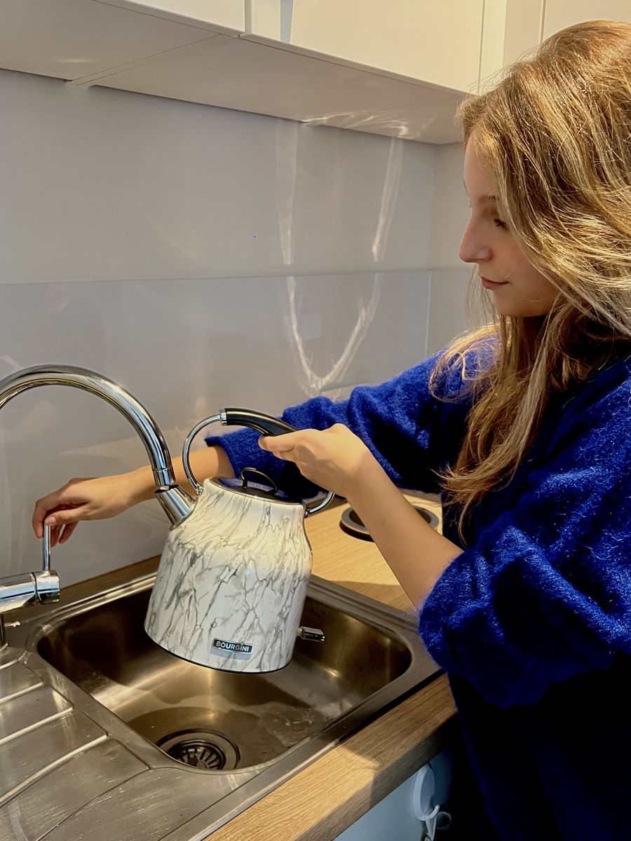 Waterkoker in gebruik aan het aanrecht