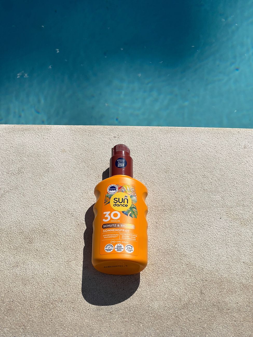 Zonnebrandspray aan de rand van het zwembad